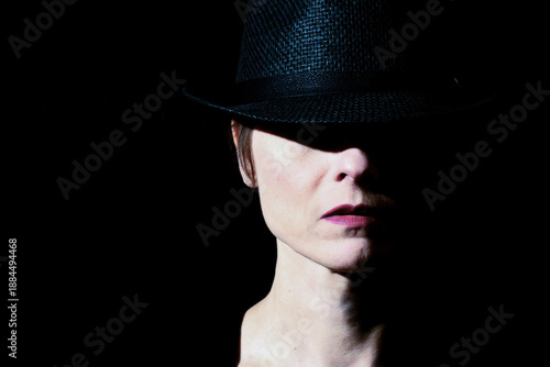 Obraz na plátne Woman wearing hat in dramatic low key portrait lighting