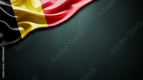 Waving Belgium national flag on a dark textured background with ample copy space.