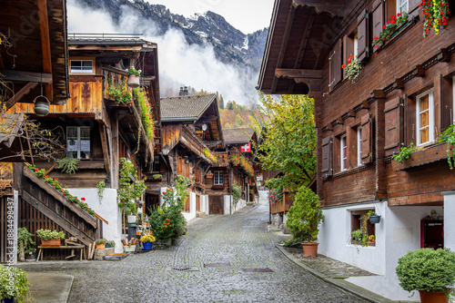 Photo of a winding street in the quaint little town of Brienz, Switzerland with the Alps in the background