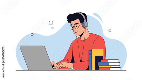 Young man with glasses and headphones working on a laptop at a desk with a stack of colorful books for education or remote work.