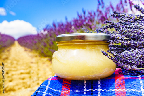 Jar with honey and lavender flowers.