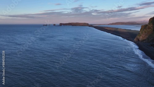 Wallpaper Mural Aerial view of the Dyrholaey peninsula where the dark sands meet the vast blue ocean under a soft, pastel sky, Vik, Myrdalshreppur, Iceland. Torontodigital.ca