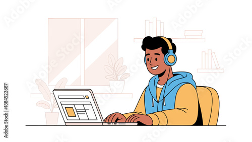 A young Black man wearing headphones is happily typing on a laptop while sitting at a desk, with a window and books in the background.
