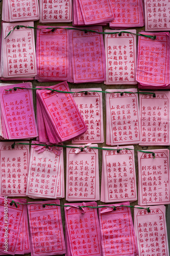 Wallpaper Mural A wooden board at a Hong Kong temple is densely covered with rows of pink paper fortune slips and prayer charms bearing traditional Chinese characters. Hong Kong, China. Torontodigital.ca