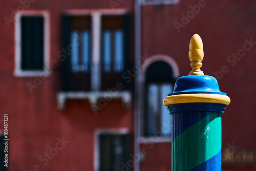 фотографія Venetian mooring post standing against blur architecture