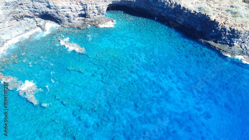Aerial drone photo of a beautiful tropical cove with coral reef in the clear blue water of Hawaii