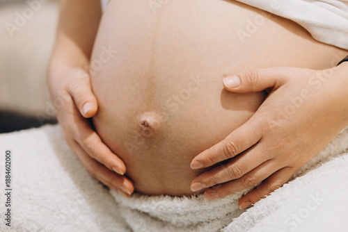 Close-Up View Of A Pregnant Belly Gently Held By Hands, Symbolizing Maternity, Prenatal Care, Body Awareness, And Maternal Connection. Intimate And Minimal Pregnancy Concept With Natural Skin Texture 