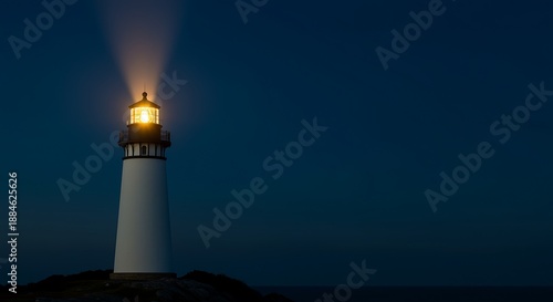 Lighthouse standing alone on rocky coastline emitting bright light beam at night