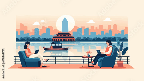 Two women work on laptops on a balcony overlooking a lake and city skyline
