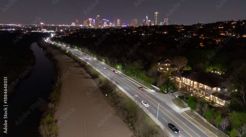 Fototapeta premium A nighttime bird's-eye view of a highway near a river and a cityscape in cinematic twilight, representing urban mobility and modern infrastructure, for travel, design, and technology presentations.