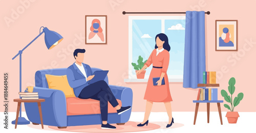 A man sits on a couch, reading a tablet, while a woman stands nearby