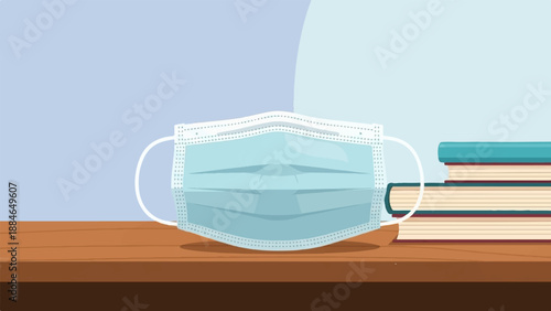 A medical mask rests on a wooden surface beside a stack of books
