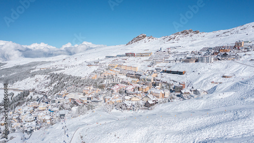 Aerial photo from dronet to Sierra Nevada ski resort on a sunny winter day in the mountains, Spain. Sierra Nevada is the largest mountain range near the city of Granada in Spain with snow. 