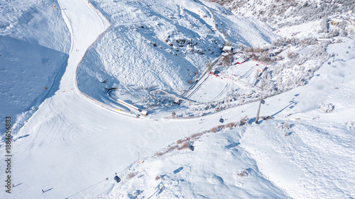Aerial photo from dronet to Sierra Nevada ski resort on a sunny winter day in the mountains, Spain. Sierra Nevada is the largest mountain range near the city of Granada in Spain with snow. 