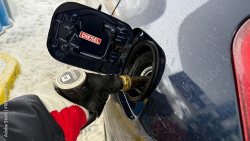 Valokuva Close-up of person hand in glove refueling diesel car at gas station with fuel p