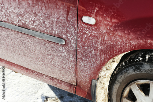 Car door covered with road salt residue. Winter driving conditions detail. Dried salt streaks on vehicle body. Seasonal car maintenance issue. Cold weather environment. Urban winter transport reality.
