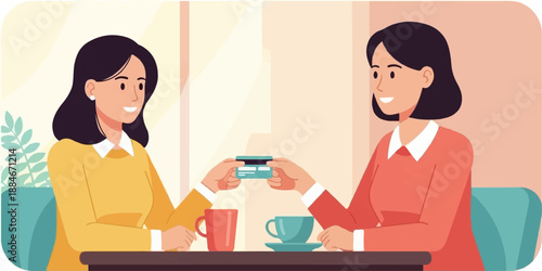 Two smiling women at cafe table exchange a credit card over coffee