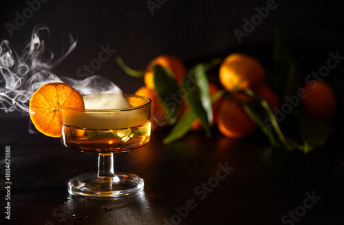 Elegant Cocktail With Orange Slice Garnish And Dramatic fresh misty effect In A Glassware Setting and Fresh Oranges in Background