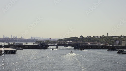 Panoramic view of Istanbul's Bosphorus Bridge with boats on water and city skyline in background. Slow motion.