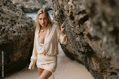 Wallpaper Mural Young woman posing between coastal rocks on sandy beach Torontodigital.ca