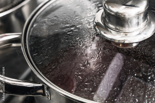 Φωτογραφία Pot with glass lid covered in steam during boiling process