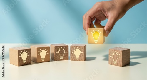 Obraz na płótnie Creative Idea Selection: Hand Picking a Glowing Lightbulb Block from a Group