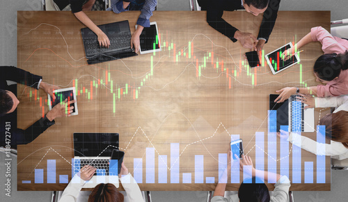 Tableau sur toile A diverse team engages in a collaborative meeting to analyze financial data using tablets and laptops, surrounded by graphs and charts showcasing market trends and insights