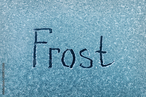 Frost Written in White on a Blue Background, Showcasing the Beauty of Winter's Touch on Surfaces