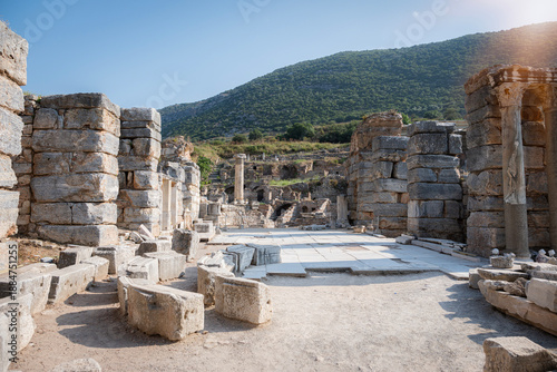 State agora in ephesus: sunlit open-air ruin with eroding stone walls, fallen columns and scattered architectural fragments revealing the enduring legacy of an ancient city