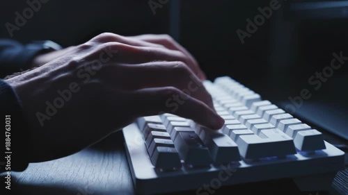 Closeup of hands typing on a keyboard in a dark room