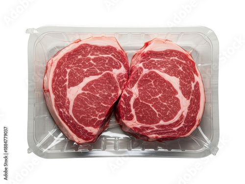 Fresh uncooked ribeye beef steaks vacuum sealed in clear plastic tray ready for grilling