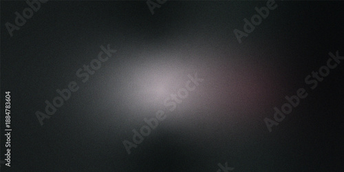 A dark grainy image with a central blurred pale and indistinct light source dominating the composition