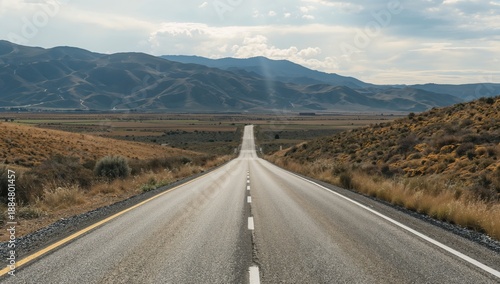Empty Road Stretches Through Countryside Under Cloudy Sky in Midday