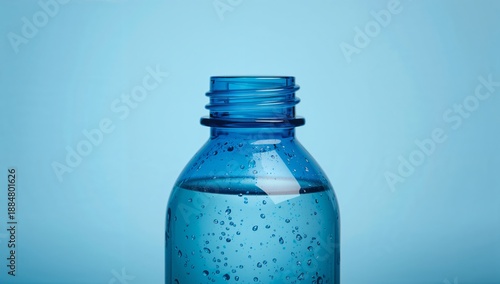 Blue Water Bottle With Clear Liquid and Bubbles Set Against a Light Blue Back...