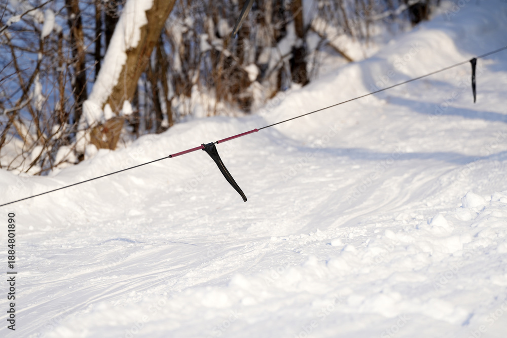 Φωτογραφία A ski and snowboard chairlift visible among the trees against the backdrop of a winter landscape, showcasing a serene outdoor environment