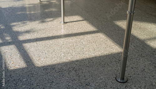 Sunlight Casts Long Shadows on the Pavement at a Train Station in the Late Af...