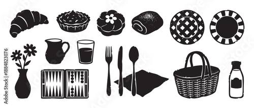 Collection of black silhouette picnic items including a basket, croissant, pastry, backgammon board, and tableware in a graphic woodcut illustration style