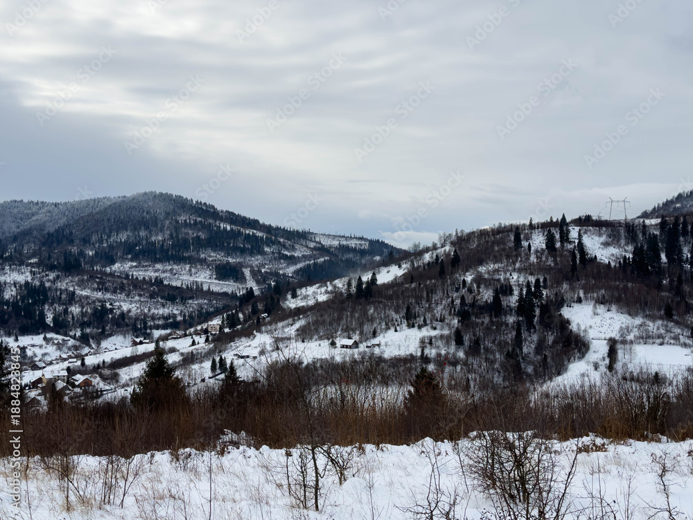 Fototapeta premium Mystical snowy Carpathian peaks under cloudy skies