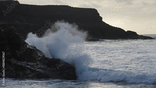 Spectacular sunset contemplating the force of the sea crashing agains the cliff