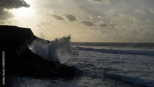 Spectacular sunset contemplating the force of the sea crashing agains the cliff