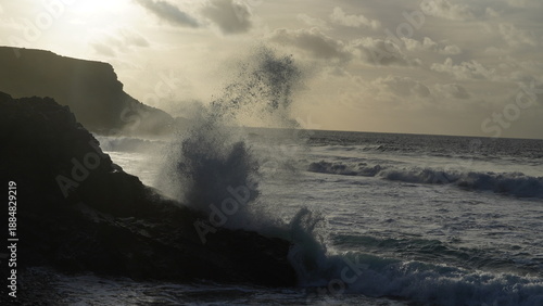 Spectacular sunset contemplating the force of the sea crashing agains the cliff