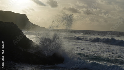 Spectacular sunset contemplating the force of the sea crashing agains the cliff