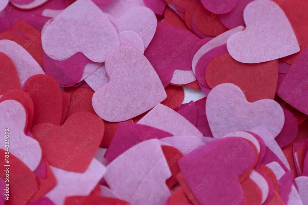 Obraz premium Layers of pink and red paper hearts — a romantic textured background for design, advertising, and Valentine's Day