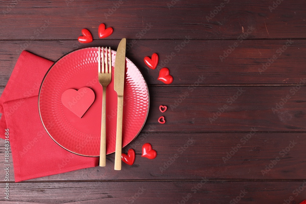 Fototapeta premium Valentine's Day. Elegant setting with cutlery and decorative hearts on wooden table, flat lay. Space for text
