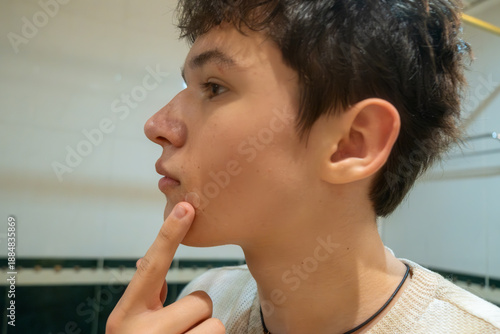 Young man applying patch on pimple, teenager's daily skin care routine for problematic young skin concept