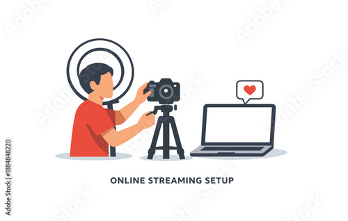 Male setting up online streaming equipment with camera and laptop