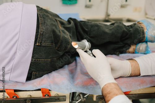 Proctologist conducts anal and rectal exam using diagnostic light.