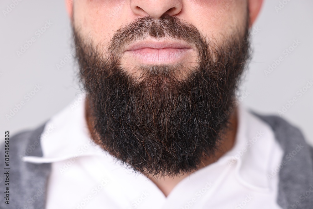 Obraz premium Man with mustache and beard on light grey background, closeup