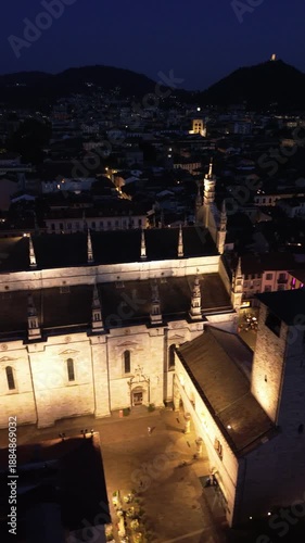 Spectacular vertical drone footage of Como Cathedral at night showcasing the illuminated dome and intricate statues with cinematic effects 2