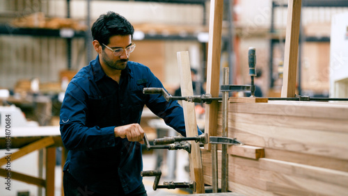 Bild auf Leinwand Male carpenter in a workshop clamping pieces of wood together, focusing on preci